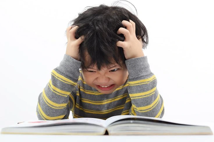 struggling boy infront of book